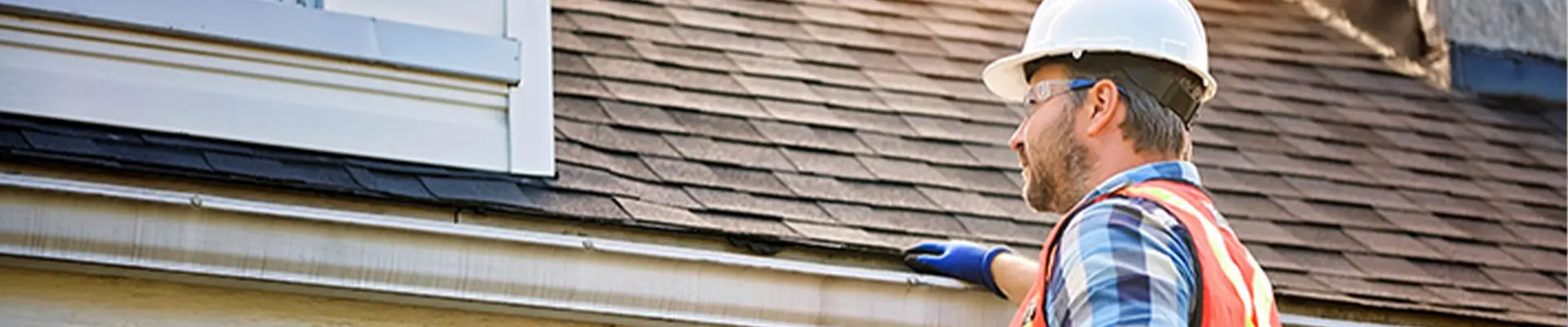 An inspector assessing roofing components and flashing details on a roof deck